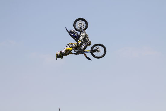 图为极限摩托车手在进行高空腾跃和后空翻表演